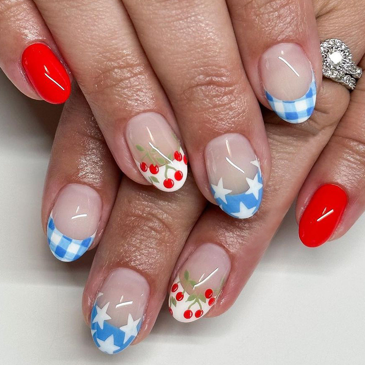 Picnic Paradise Short Length Oval Press On Nails with Gingham, Cherry, and Star Accents in Blue, Red, and Neutral Tones