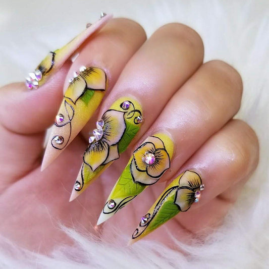 Tropical Elegance Long Stiletto Yellow Press-On Nails with Green Leaf Patterns and Rhinestone Embellishments