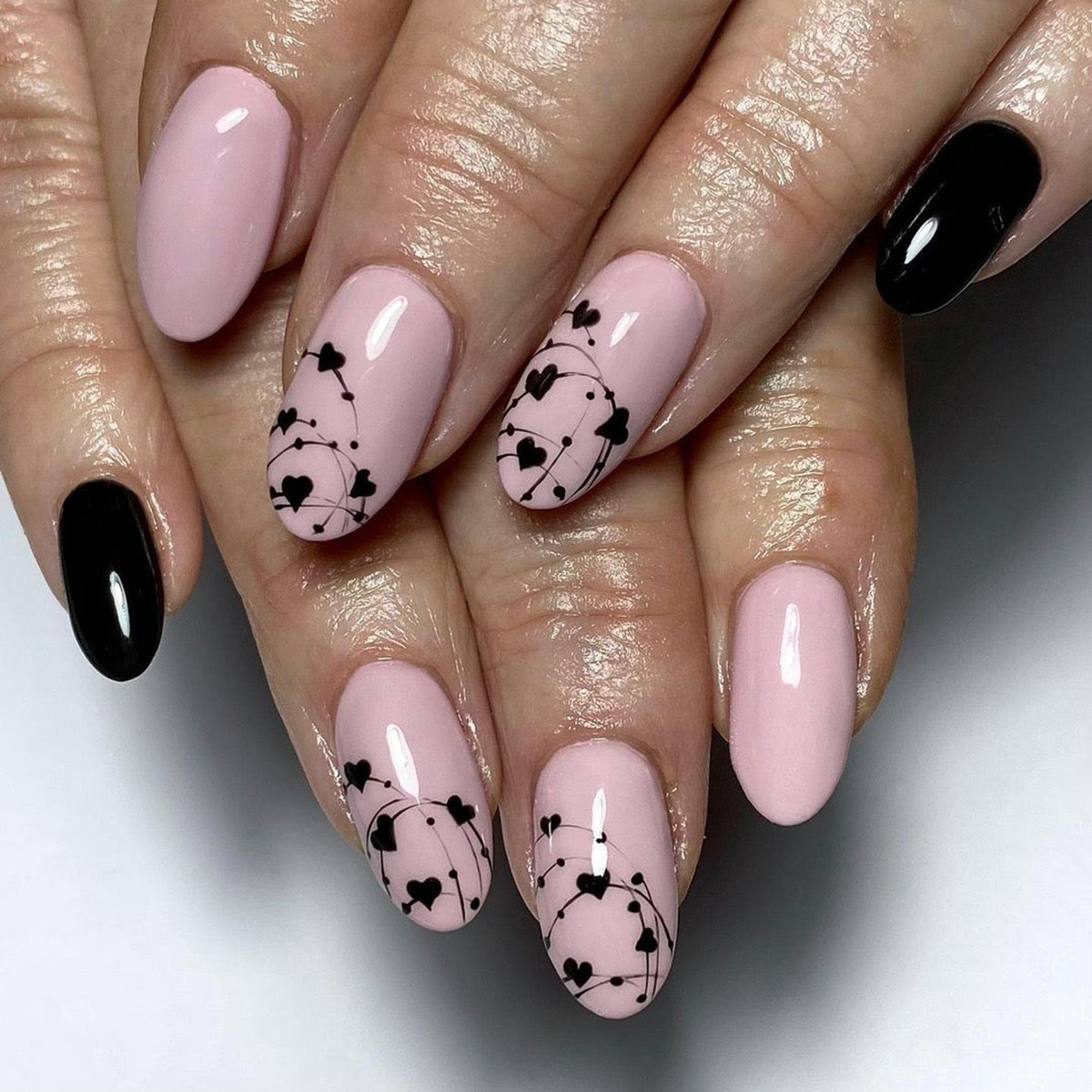 Chic Medium-Length Oval Pastel Pink Press-On Nails with Elegant Black Floral Art and Glossy Finish