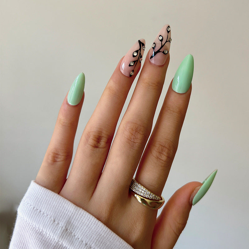 Elegant Mint Green Long Almond Press On Nail Set with Black Accent Swirls and Rhinestone Embellishments