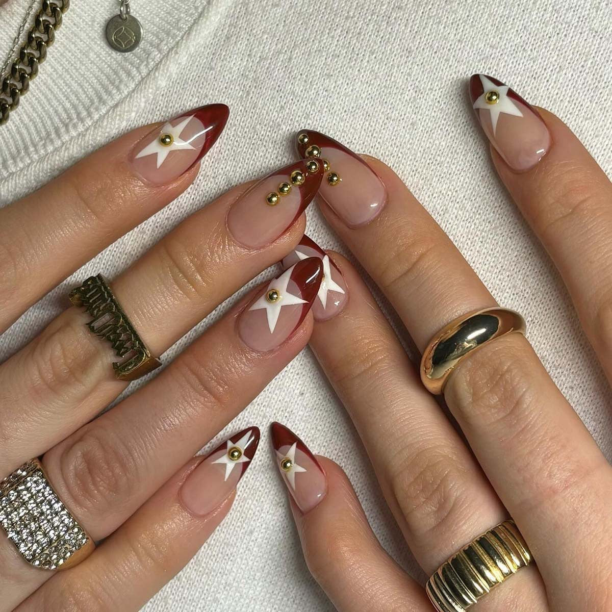 Elegant Stardust Collection Medium Almond Burgundy and Beige Press On Nail Set with Gold Studs and Stars Design